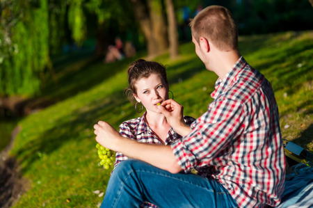 happy young couple bite grapes. Toned imageの写真素材