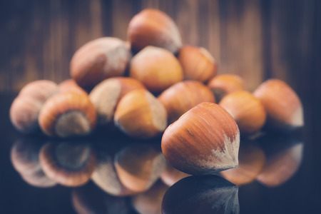 toned photo of Hazelnuts, filbert on wooden background. Selective focus