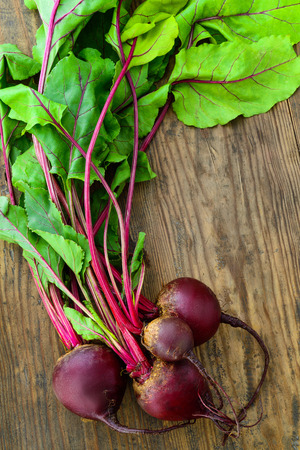 Young Raw Organic Red Beets on wooden table.