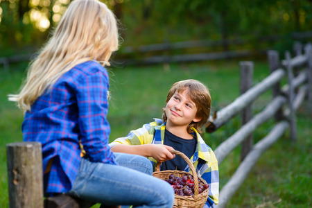 happy kids eating fruits from picnic basket outdoor. romantic or first love concept.の写真素材