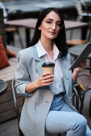 serious businesswoman holding tablet and cofee at city cafeの写真素材