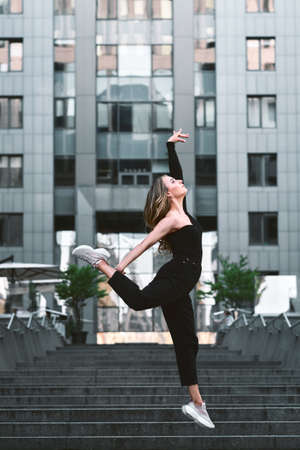 fashion portrait of young stylish beautiful woman jumping in a urban backgroundの写真素材