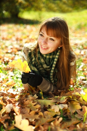 Outdoors portrait of autumn happy girl in yellow leavesの写真素材
