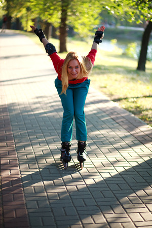 Happy young girl enjoying roller skating in park, active woman outdoor