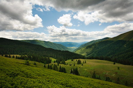 Landscape green mountains on blue sky background and white cloudsの写真素材