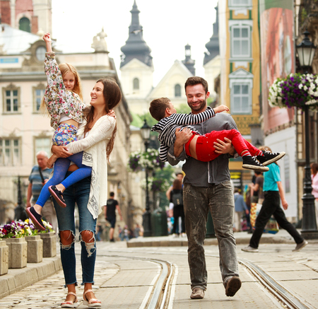 Young family with two kids walking the street of the old tourist cityの写真素材