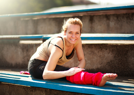 Young athletic woman dancer doing exercises in the old city stadium