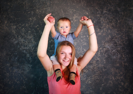 Portrait in studio young mother with her little son in arms happy togetherの写真素材