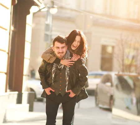 Romantic happy young couple in love in a tourist city having fun together in sunset lightの写真素材