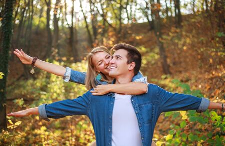 Happy couple guy and girl in the forest park have fun together, people in love, concept of freedom...