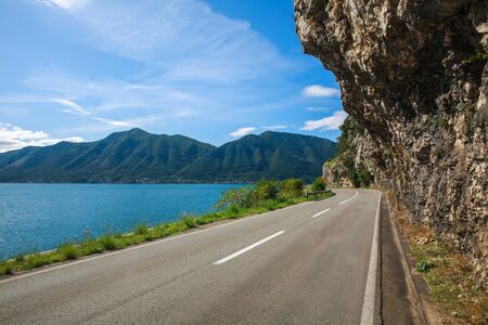 Asphalt road along the sea bay and mountains against the blue sky, Europe, Montenegro, Kotorの写真素材