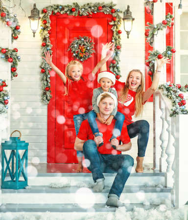 Happy family in Christmas in yard of New Year's decoration house, tradition of celebratingの写真素材