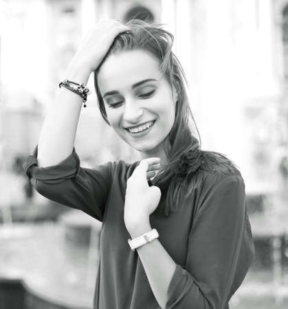Black and white portrait of a joyful girl on the background of the street of an old European cityの写真素材