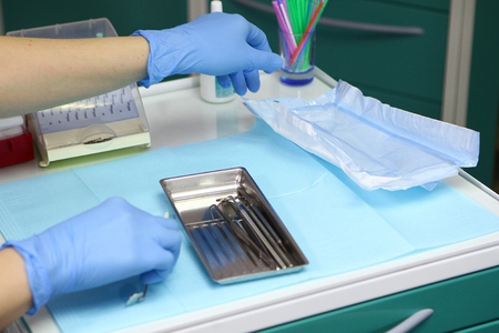 The hands of the doctor in gloves take the equipment for the work of the dentist. The concept of beauty and health.Photov doctor's officeの写真素材