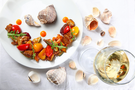 Salad from vegetables and rapanov meat. Meat shells rapanov from the Sea of Azov. Grilled vegetables with a great sauce. Blackberry top view.の写真素材