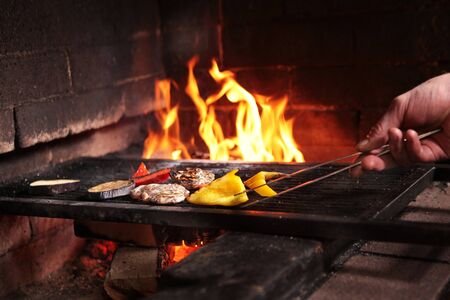 A piece of chicken and vegetables are grilled. Open fire in the oven. The concept of cooking on the grill. Photo without a face.の写真素材