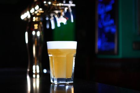 A large glass of beer at the bar. Restaurant concept. Copy space. Macro photo on a black background.