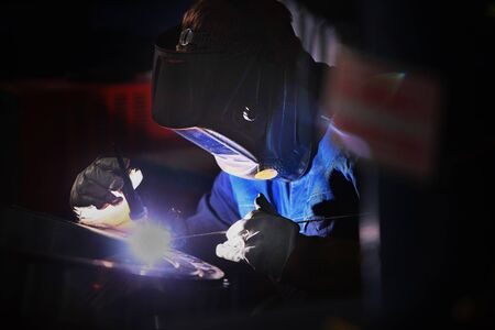 Welder In a protective helmet at the workplace. Photo without a face. The concept of professions...