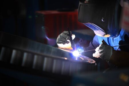 Welder in a protective helmet at the factory. Photo without face with copy space. The concept of...