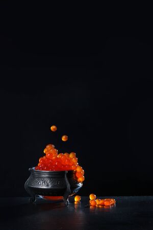 Red caviar on a black background. Vintage vase on the table. Gourmet Concept.の写真素材