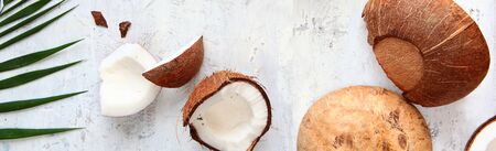Pieces of coconut and leaves of a tropical tree on a light textured background. A narrow banner. Top view. Copy space.の写真素材
