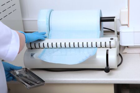 Craft bags for sterilization in a roll. Special packaging equipment for dental devices. Concept of...