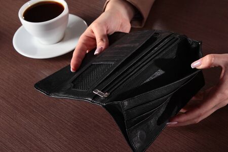 An empty purse in a woman's hands. The concept of the financial crisis. Unrecognizable photo without...