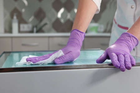 Disinfection of surfaces in the dental office. Close-up of a gloved hand. Copy space. Unrecognizable photo. Only hand.の写真素材