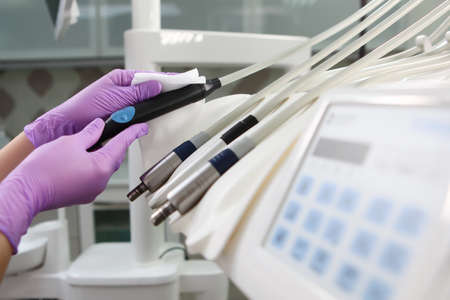 Disinfection in the dental office. A nurse wipes the dental unit. Gloved hand. Unrecognizable photo....