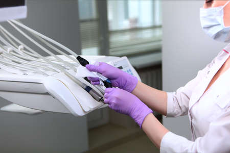 A nurse wipes dental instruments. Disinfection in dentistry. Unrecognizable photo. Copy space.