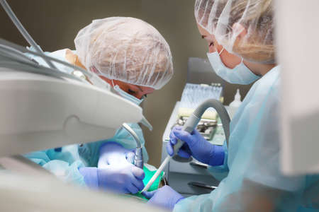 Dentist and assistant during work. Removal of caries under General anesthesia in a child. Copy of the space.の写真素材