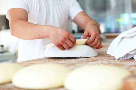 Close-up of the Baker's hands. Preparation of flat cakes from yeast dough. The concept of baking or...