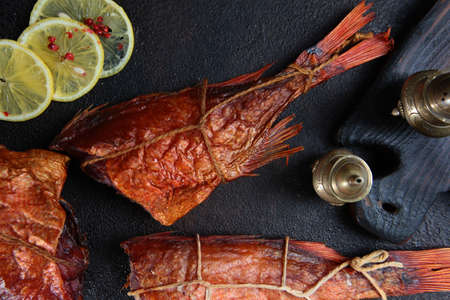 Smoked sea bass on a black background. Marine useful fish. Top view.
