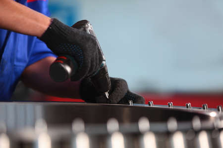 Production of bearings. Heavy industry. The worker's hands are gloved. An unrecognizable person....