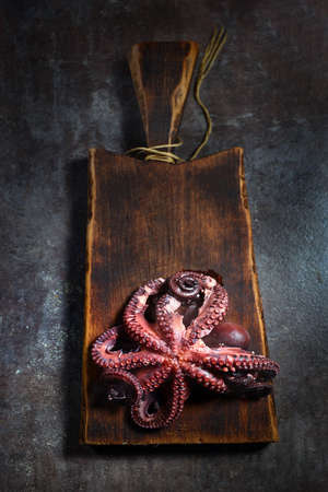 Boiled octopus on a wooden board. Top view. Cooking seafood. Low-calorie food. The concept of cooking seafood. Free space.の写真素材