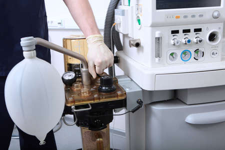 The anesthesiologist turns on the machine for artificial ventilation of the lungs. Surgery under...