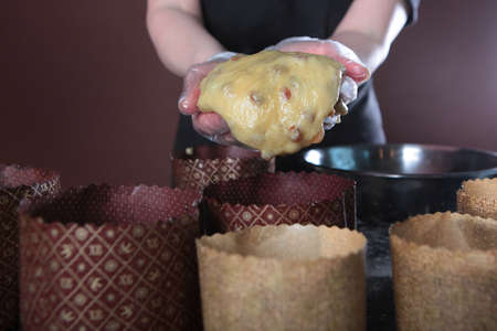 A pastry chef holds cashew nuts in his hands. Nuts are added to the dough for cakes. Ingredients for...