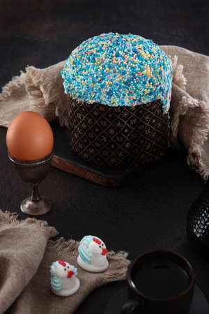 Easter cake in a festive package on a light background. Willow branches.Concept of the Easter holiday. Free space. Chicken eggs on wooden stands.の写真素材