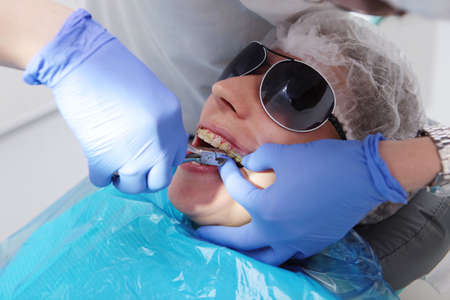 Dentist takes pictures of the patient's teeth. Malocclusion. Orthodontist work. Frach is out of focus. Vertical photo.の写真素材