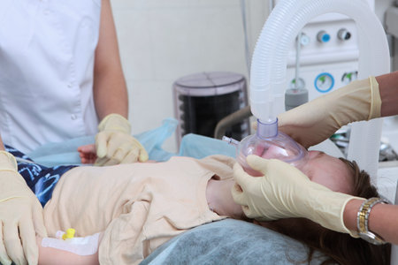 Preparing the child for surgery. Oxygen mask on the face. Unrecognizable people. Saving life....