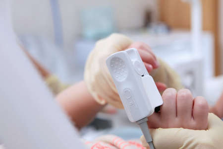 Measuring the oxygen level in the blood of a child. Pulse oximeter on a child's finger. Preparing for surgery. Out of focus.Close-upの写真素材