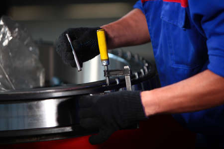 Large diameter bearing is assembled at the factory. The worker assembles the bearing by hand. Bearing production. Heavy industry. Unrecognizable person. Only hands.の写真素材