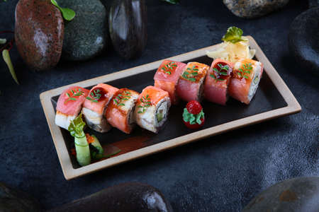 Rolls with smoked salmon, eel and tuna. Rolls Kaisen. Avocado inside rolls. Dark background....