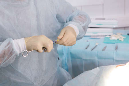 Modern dentistry. Doctors hands with a syringe. Anesthesia before tooth extraction and implant placement. Only hands. With copy spaceの写真素材