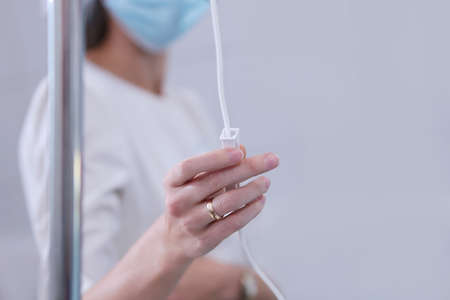 Dropper with medicine. The doctor regulates the delivery of the medication. Doctors hand.の写真素材