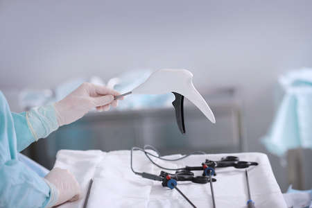 Medical instrument for laparoscopic surgery in the hand of a nurse. Life saving. Modern surgery. Gloved hands. Unrecognizable person.の写真素材