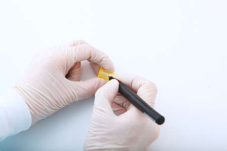 A syringe in the hands of a nurse. Taking tests in a medical laboratory. Hands in protective gloves close-up.の写真素材