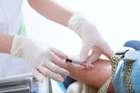 A syringe in the hands of a nurse. Taking tests in a medical laboratory. Hands in protective gloves...