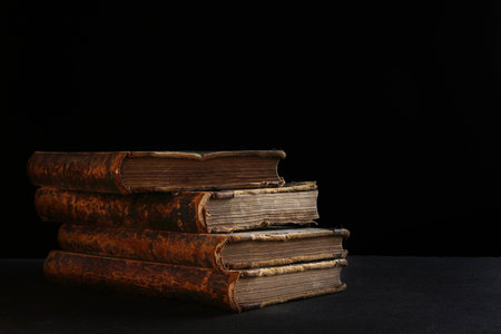 Old books.Four volumes of old books on a black background. The old library. The concept of knowledge...