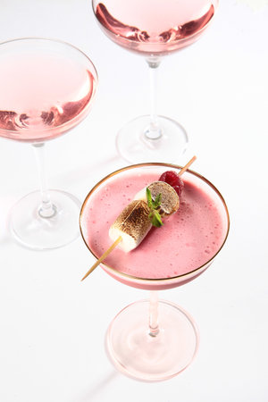 Pink alcoholic cocktail decorated with marshmallows. Pink cocktail in a tall glass. Photo on a white background. Isolated object. White background.Vertical photo.の写真素材
